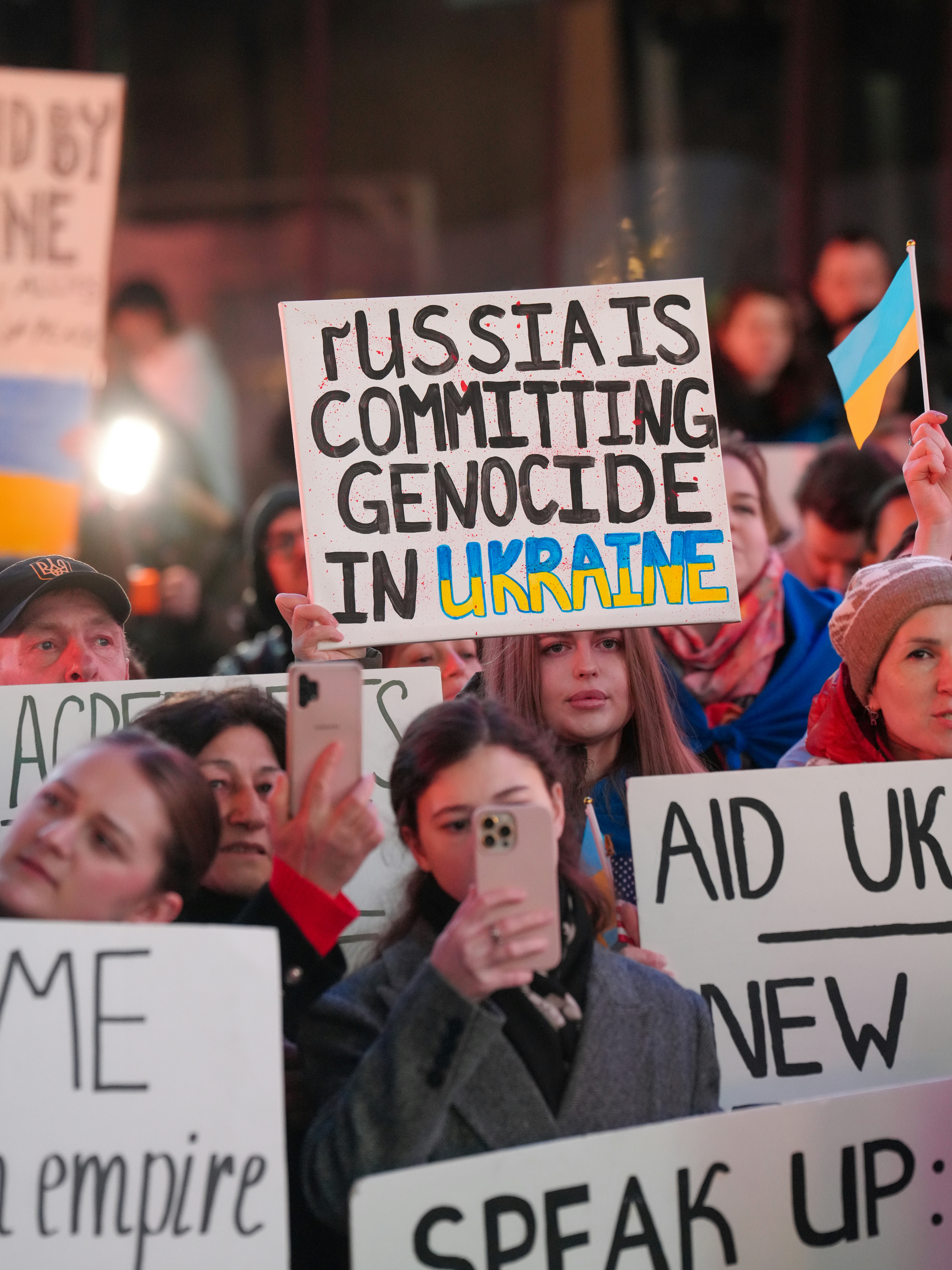 A young woman holds up a sign reading \